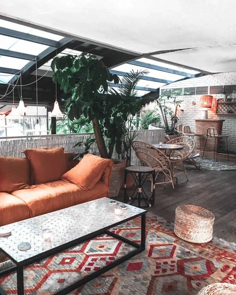 A living room with orange furniture and a glass table.