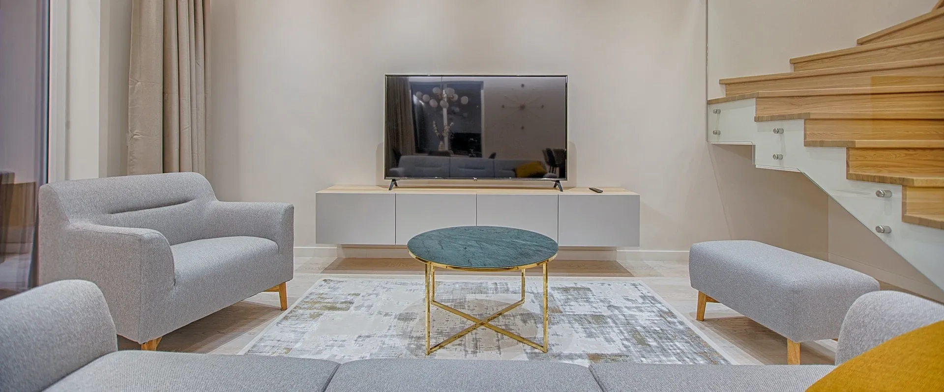 A living room with a table and tv on the wall