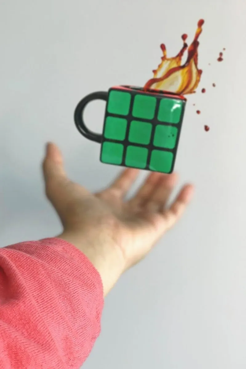 A hand is holding up a rubix cube