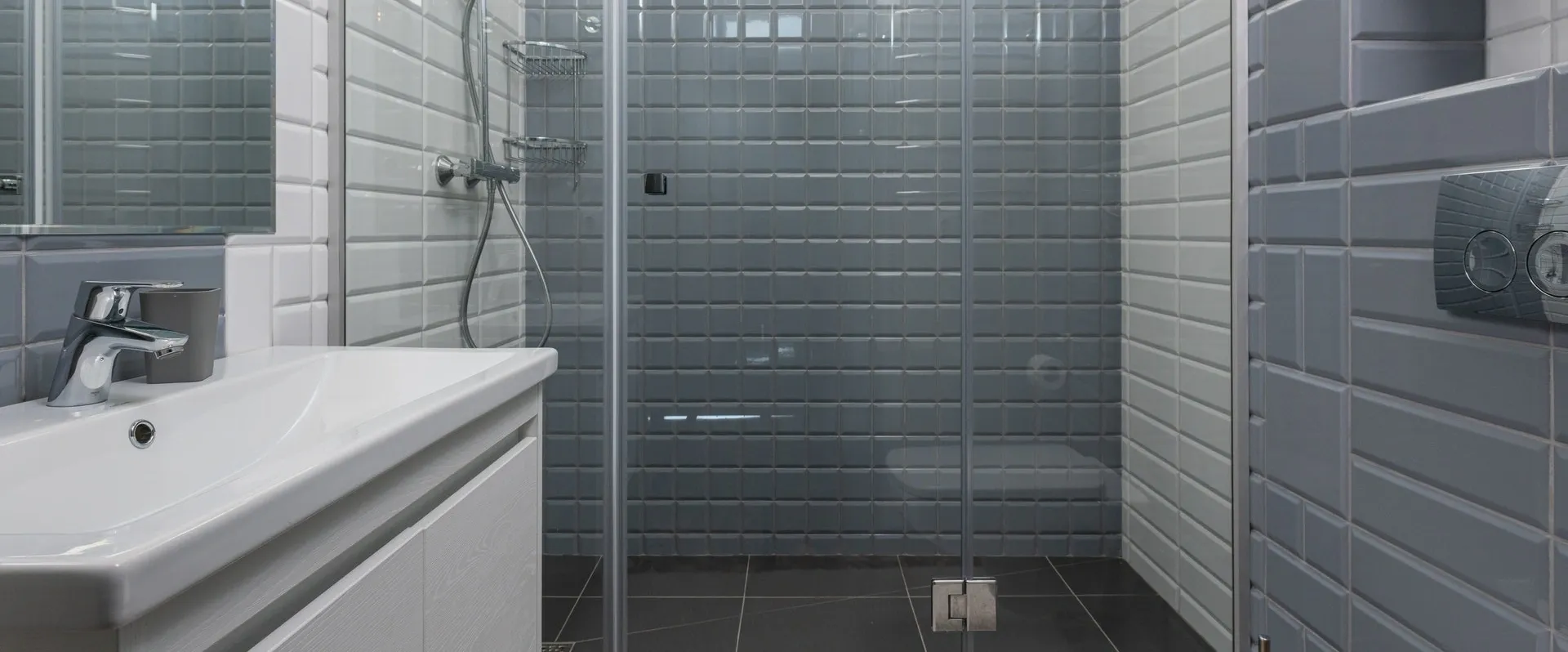 A bathroom with a shower and tiled walls.